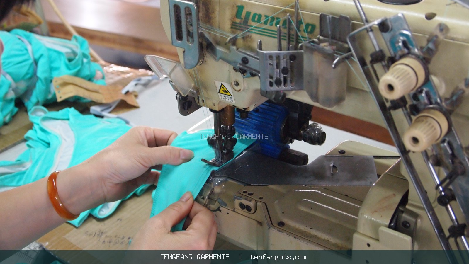 Close view of swimwear being sewn on an industrial machine